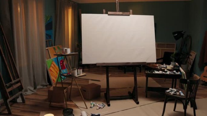 工作区，画家的工作室，带有大画架的艺术家，房间中间有画布。画布周围散落着油漆、刷子、纸箱，一片狼藉