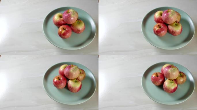 有机苹果放在转动的厨房桌子上的盘子里
