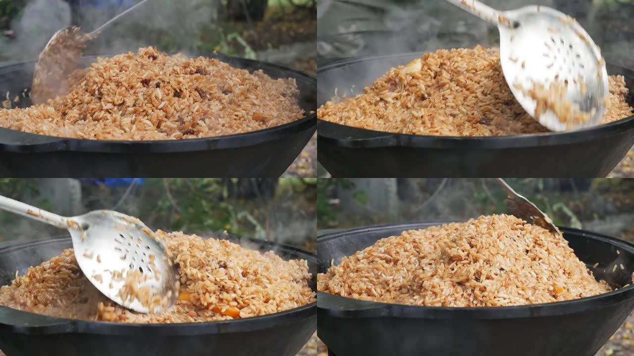 大厨撇渣器在大型铸铁大锅中使热抓饭变得平整
