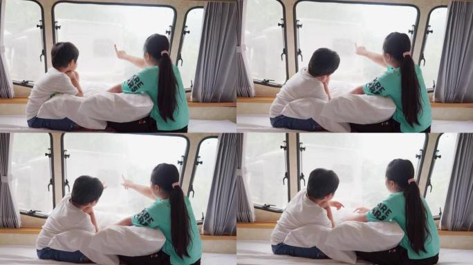 假日早晨，亚洲兄弟姐妹在露营车中放松身心，窗外可以看到风景