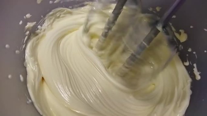 电动搅拌机将蛋清鞭打成蓬松的奶油。