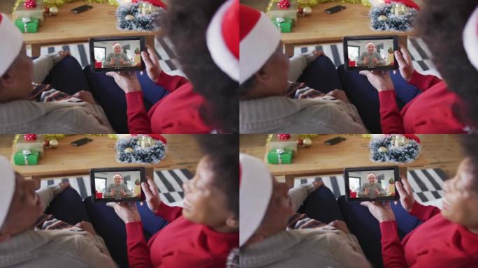非裔美国母亲和女儿使用平板电脑与屏幕上的男人进行圣诞节视频通话