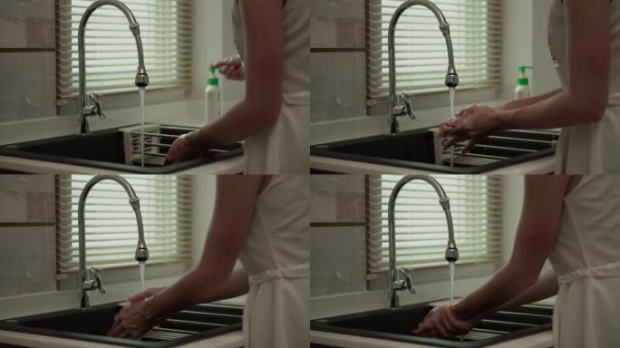 妇女正在用泡沫肥皂和清水洗手。洗手保持清洁，防止病毒传播。