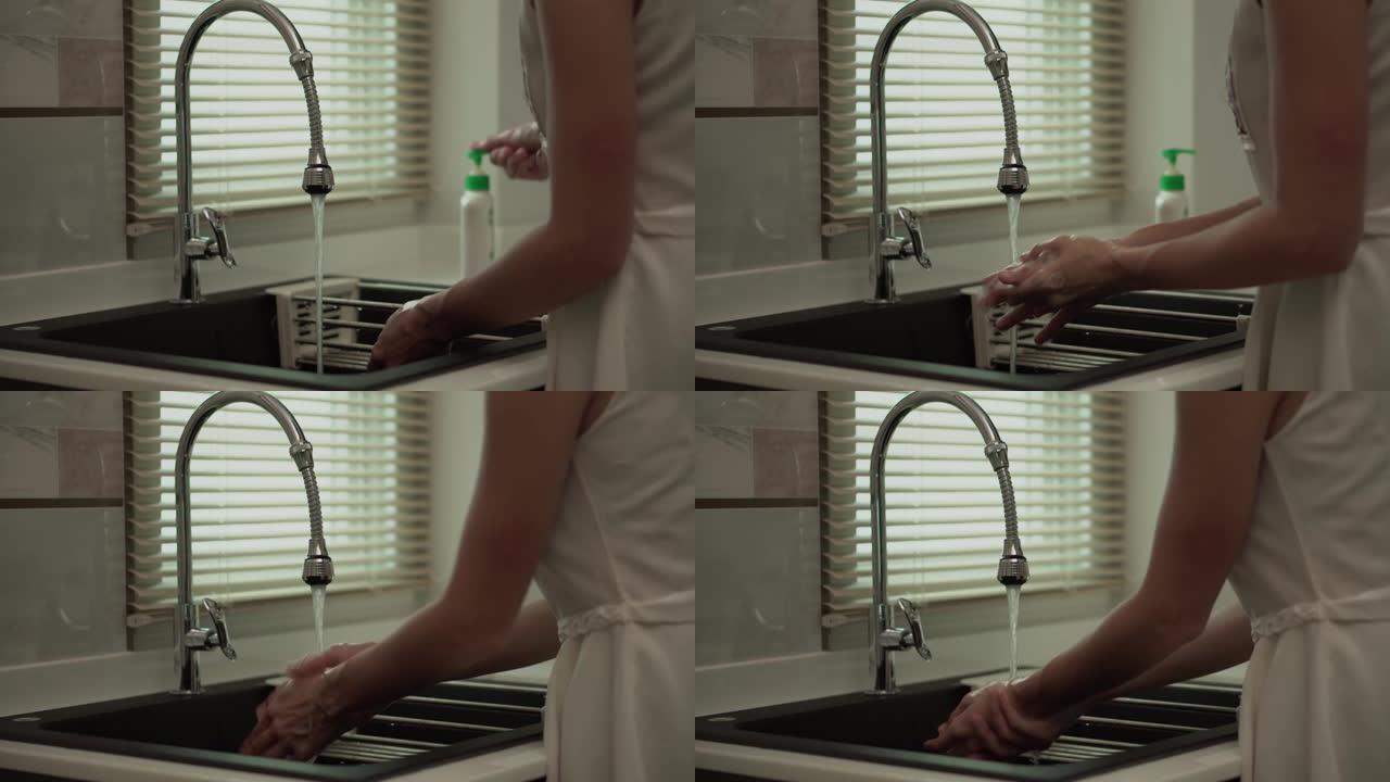 妇女正在用泡沫肥皂和清水洗手。洗手保持清洁，防止病毒传播。