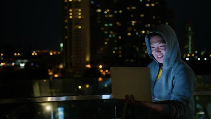 聪明的积极微笑亚洲男性商人视频会议远程工作讨论晚上的协奏曲以建筑光城博克科技为背景
