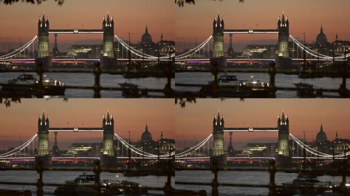 伦敦塔桥和圣保罗大教堂的圆顶在晚上从泰晤士河的河岸