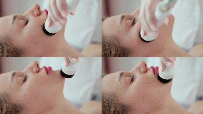 面部提升、皱纹平滑和押韵消除程序。美容师在女性脸上移动机械手。美容和水疗概念。