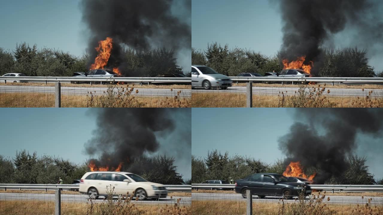 在阳光明媚的蓝天下，夏季发生事故后，汽车在主要高速公路上燃烧着大火和黑烟。道路交通事故。交通事故。险