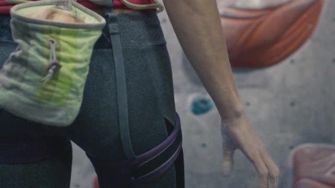 运动女运动员用镁攀岩。一个独奏在室内健身房接受训练。袋装手掌爽身粉