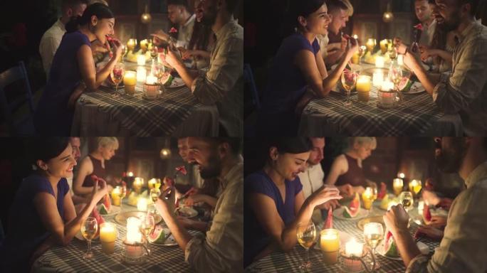 可爱的夫妇和他们的朋友一起享受宁静的晚宴