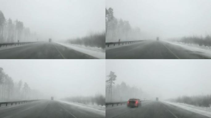 冬季，在能见度差的大雪和卡车上，通过高速公路上的汽车挡风玻璃观看