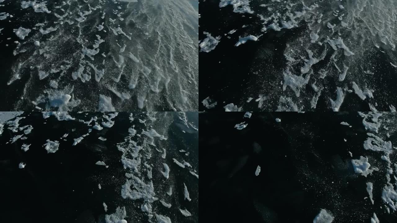 雪在冰面上飞舞。雪花在贝加尔湖的冰上飞舞。冰非常美丽，有不同寻常的独特裂缝。雪光闪烁。