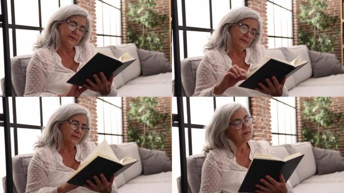 中年白发女子专心在家看书