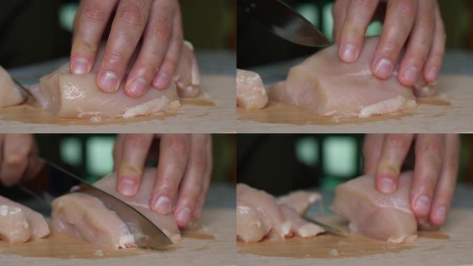 在切好的木板上关闭鸡柳。男人的手刀在木切板上切片精致的火鸡鱼片。厨师切鸡胸肉，生白肉，厨师煮鸡胸肉，