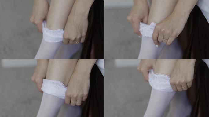 一位女士穿上白色尼龙丝袜，上面系有花边松紧带