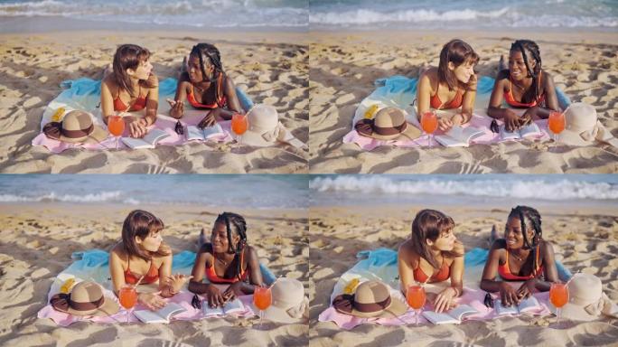 两个混合种族的年轻女孩在海滩上晒日光浴