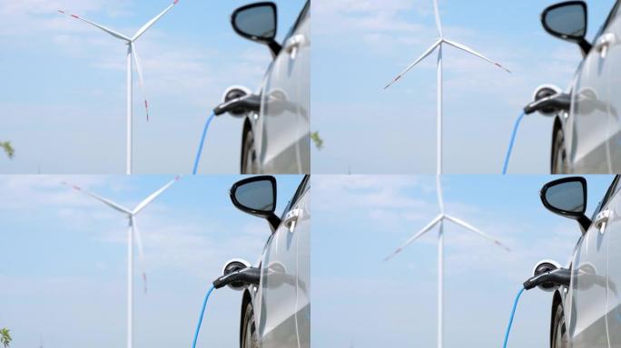风车在由交替能量充电的电动汽车附近旋转