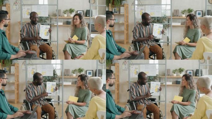 坐在轮椅上的非洲人在办公室会议上介绍商业计划