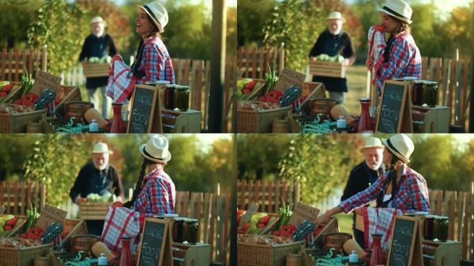 成熟的女农夫清洁番茄并准备出售，而爷爷从花园里带来了一箱蔬菜