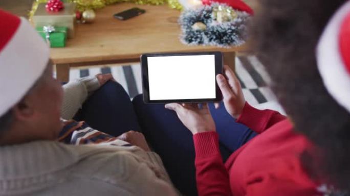 非裔美国母亲与女儿进行平板电脑圣诞节视频通话，在屏幕上复制空间