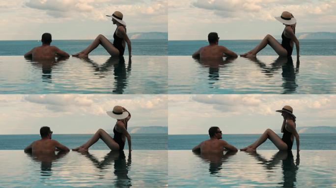 夫妇在豪华度假村的无限游泳池享受浪漫海景