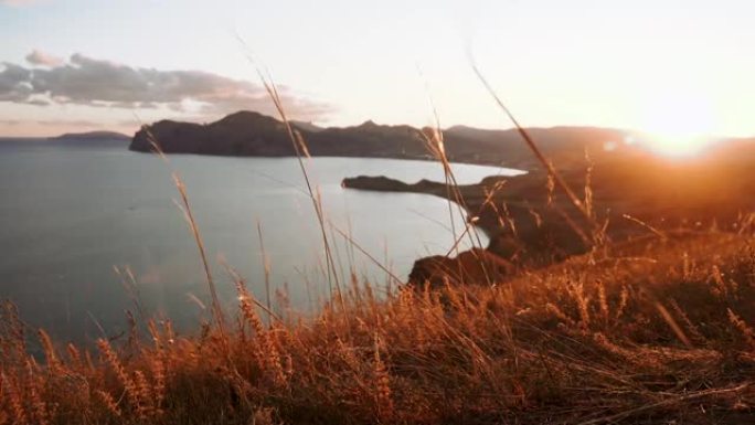 4k视频。令人惊叹的日落景观，可以看到科克特贝尔克里米亚变色龙角。专注于山腰上挥舞的草地