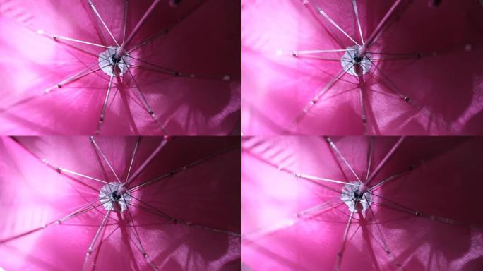 秋季背景与旋转粉色雨伞特写。孩子打伞，在家玩