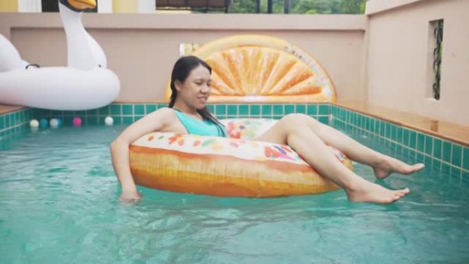 东南亚人以滑稽的方式在后院游泳池玩水