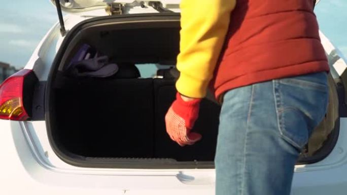 一名男子从汽车后备箱中卸下冬季轮胎