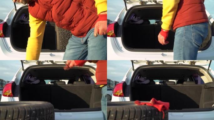 一名男子从汽车后备箱中卸下冬季轮胎