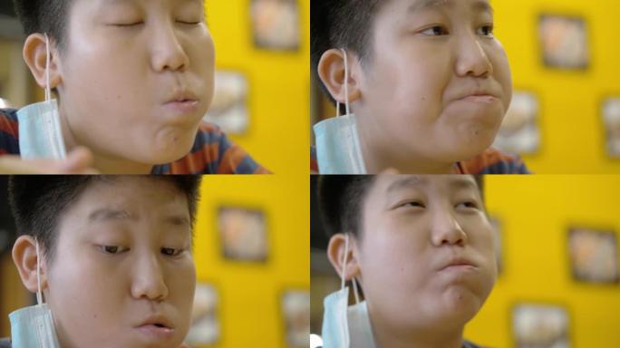 快乐的亚洲男孩和家人一起在日本餐厅享受他的食物，生活方式理念。