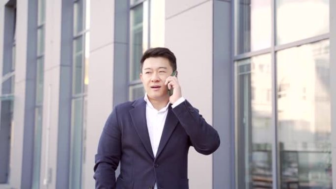 肖像成功的年轻自信商人谈话背景市中心的现代办公楼。