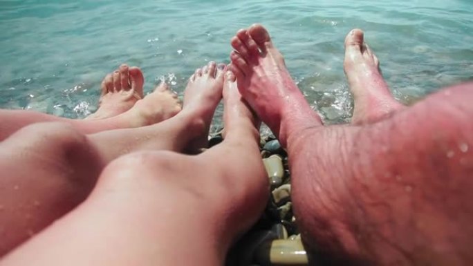 这些是一个家庭在石岸海浪中的赤脚