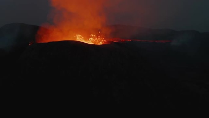 围绕活火山火山口拍摄的轨道。热沸腾的岩浆。反射光辉的流出火山气体。法格拉达尔斯福杰尔火山。冰岛，20