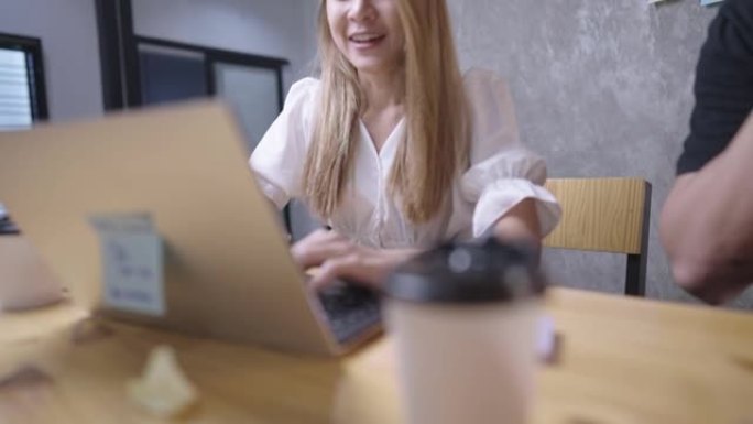 在办公室环境中特写镜头，年轻快乐的金发女工和她的拼贴画一起笑，工作场所的幸福，团队合作的成就，使用笔