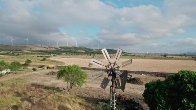 农场的后院风车和背景中的许多风电场。小型风车和风电场之间的对比，小规模电力生产 ..