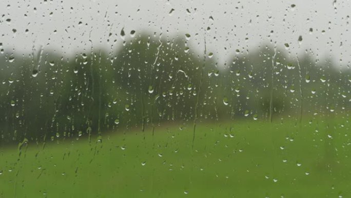 玻璃上的雨滴。夏天的雨滴从窗户流下。窗外下雨。淋浴天气不好。平静放松的冥想平静的背景。阴雨天气秋天抑