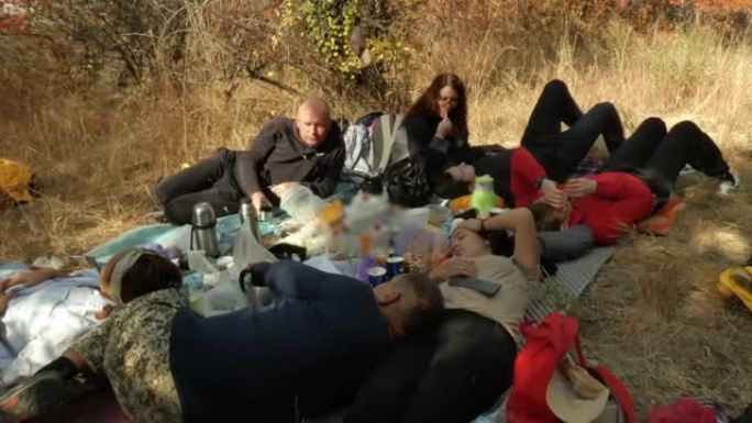 秋日野餐的游客在地上休息。