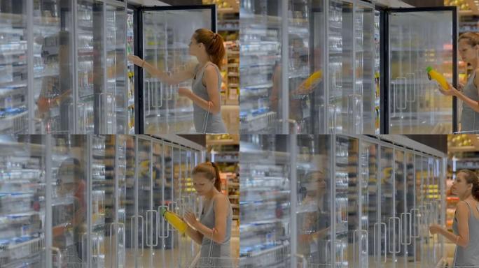 年轻的美国女性顾客正在杂货店购买果汁