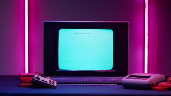 粉红色霓虹灯背景上带有蓝色屏幕的旧电视。老式电视和复古playstation的特写镜头，更换墨盒。古