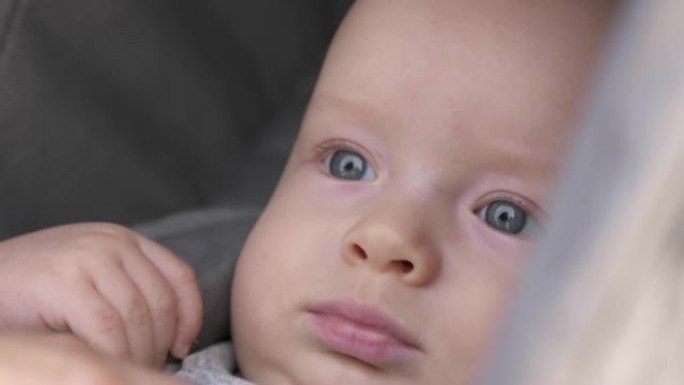 男婴坐在婴儿车里的脸，可爱的高加索六个月大的孩子在户外。