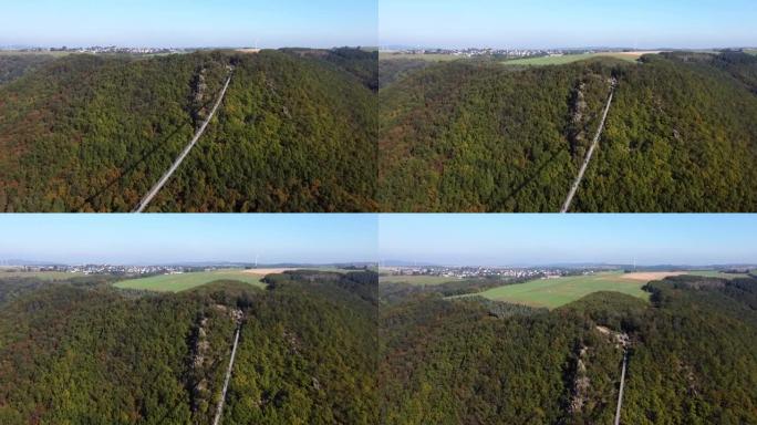 视频来自一架无人机，用钢绳飞过一座悬吊的木桥，飞越西德一片茂密的森林，可见的游客在桥上行走。