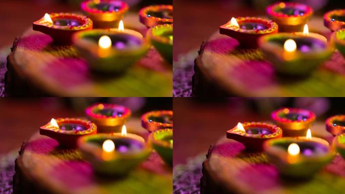 在紫色到绿色的编织表面上圆形发光的排灯节蜡烛的视频