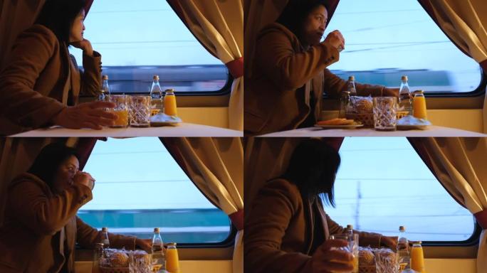 穿着棕色外套的亚洲女人吃早餐，独自乘火车旅行，透过窗户看风景