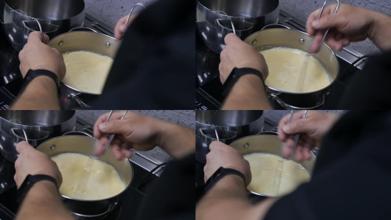 从肩膀拍:一名糕点师正在平底锅里搅拌液体