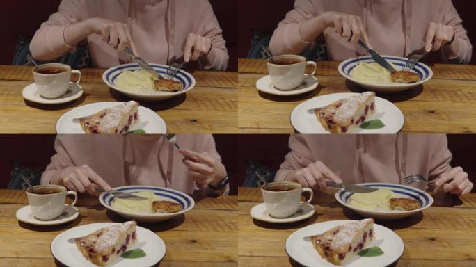 一个穿着粉红色连帽衫的女孩在一家餐馆用餐，吃鸡排和土豆泥