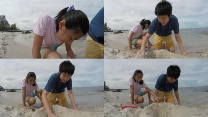 快乐的亚洲儿童在度假时与家人一起在沙滩上玩沙子，生活方式理念。