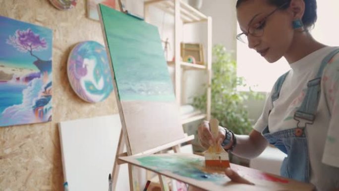 年轻女艺术家在家绘画