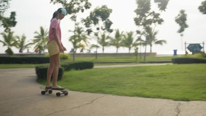 亚洲女孩在公园户外玩冲浪滑板，早晨，白天，生活方式的概念。