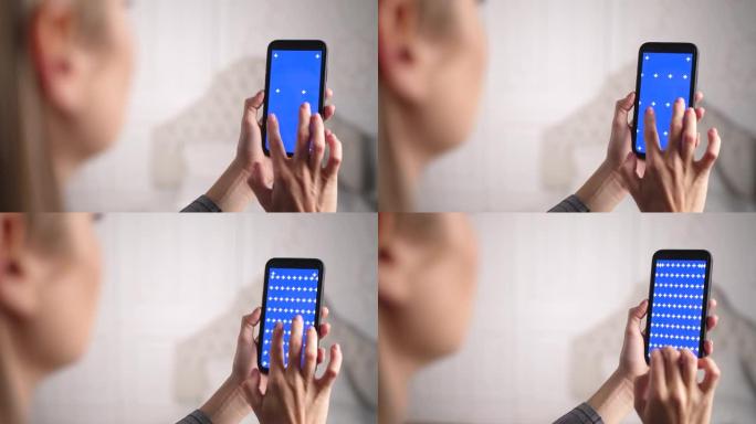 女性用手指放大和缩小蓝色彩色屏幕。